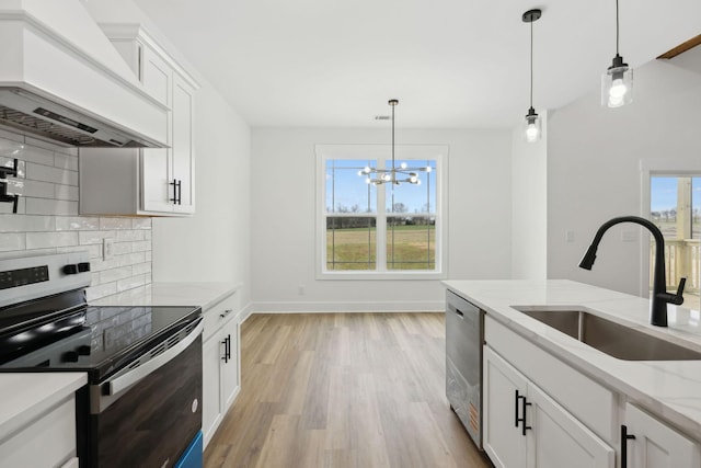 kitchen with stainless steel appliances, a sink, light wood-type flooring, tasteful backsplash, and custom range hood