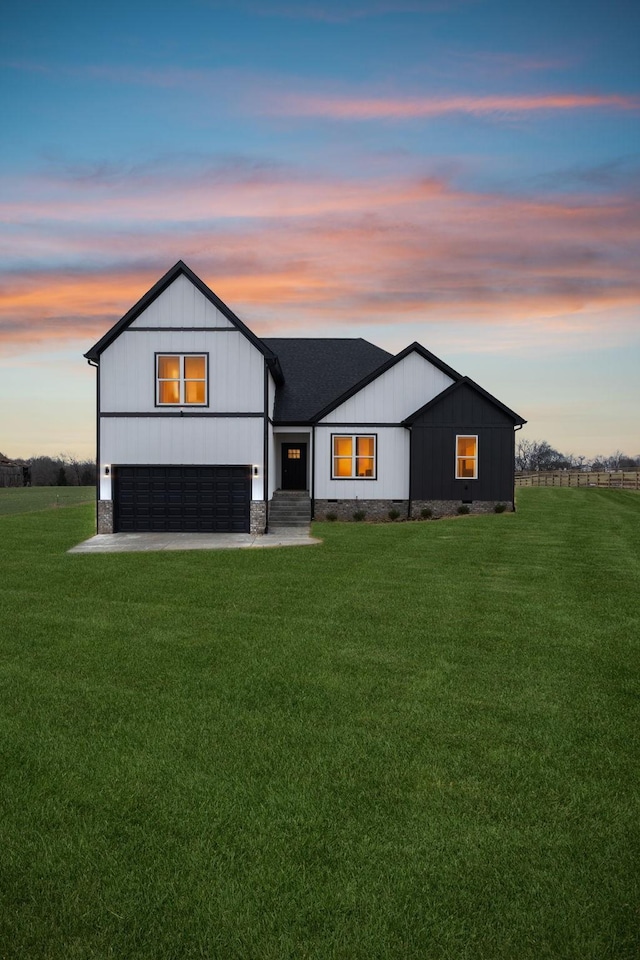 modern farmhouse featuring a yard, driveway, and a garage