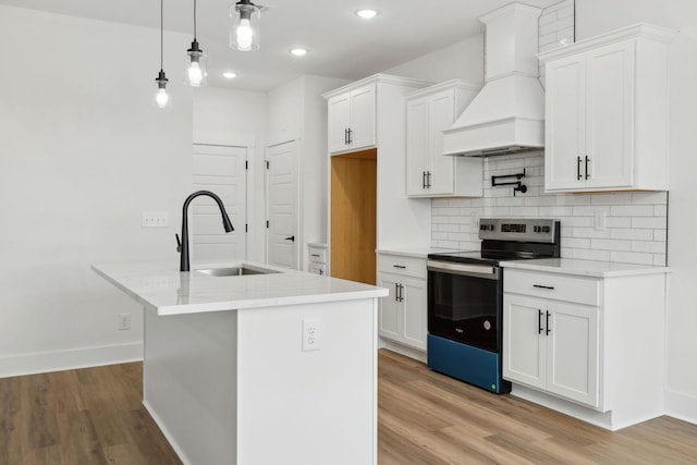 kitchen with light wood-style flooring, premium range hood, a sink, backsplash, and stainless steel electric stove