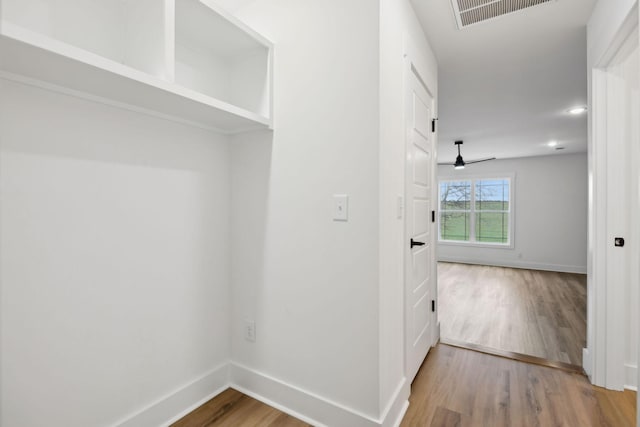 corridor with visible vents, baseboards, and wood finished floors