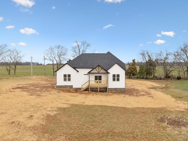 rear view of house featuring a shingled roof and crawl space