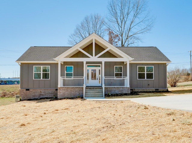 view of front of property with crawl space, a porch, board and batten siding, and roof with shingles