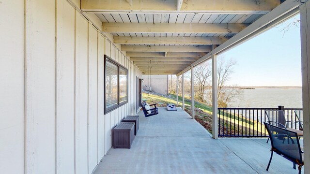 view of patio with covered porch and a water view