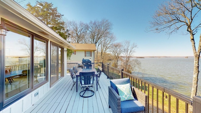 wooden deck featuring grilling area and a water view