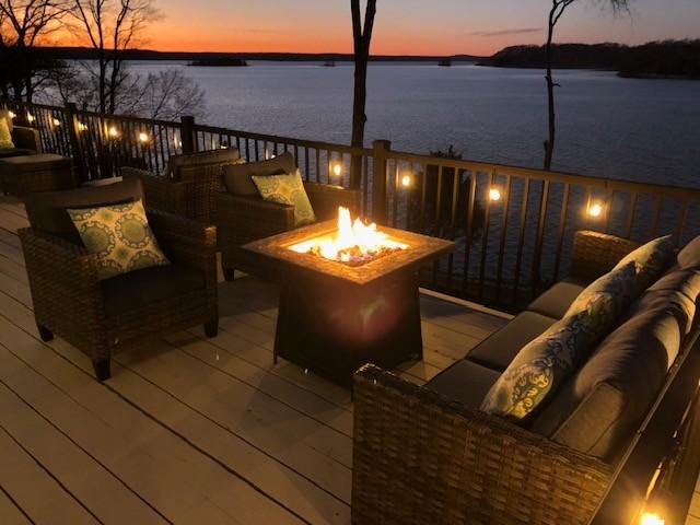 deck featuring an outdoor living space with a fire pit and a water view