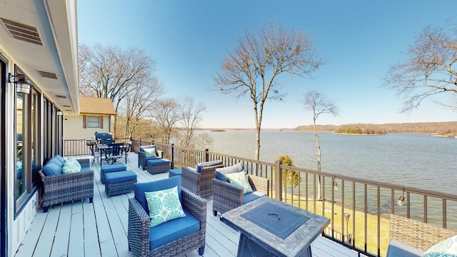 wooden terrace with visible vents, a water view, and an outdoor living space