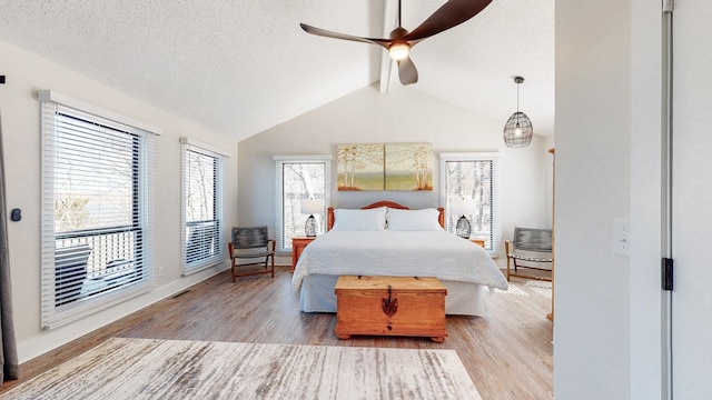 bedroom featuring lofted ceiling with beams, a textured ceiling, wood finished floors, and visible vents