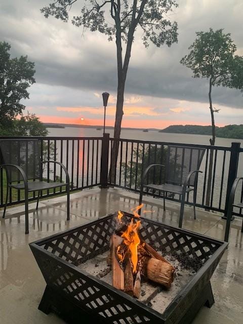 balcony featuring a water view and a fire pit