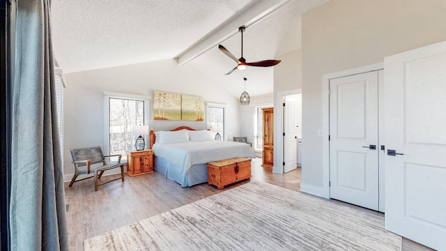 bedroom featuring a textured ceiling, high vaulted ceiling, baseboards, beam ceiling, and light wood finished floors