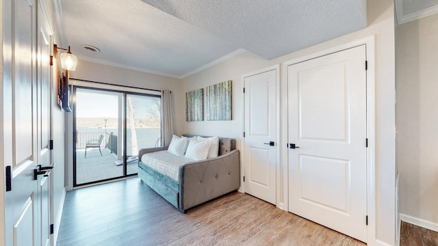 bedroom featuring access to exterior, crown molding, visible vents, and light wood-style floors