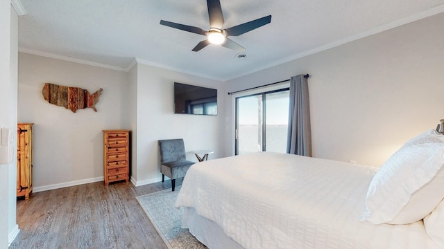 bedroom featuring a ceiling fan, crown molding, baseboards, and wood finished floors