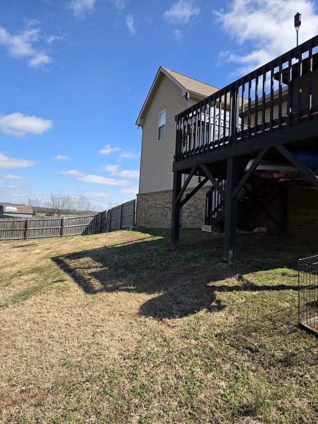 view of yard with a deck, stairs, and fence