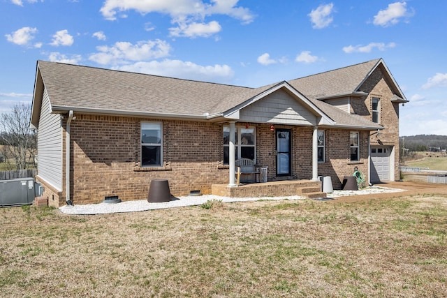 single story home featuring crawl space, brick siding, roof with shingles, and a front yard