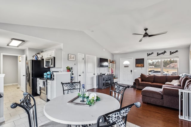 dining space with vaulted ceiling, light tile patterned floors, and ceiling fan