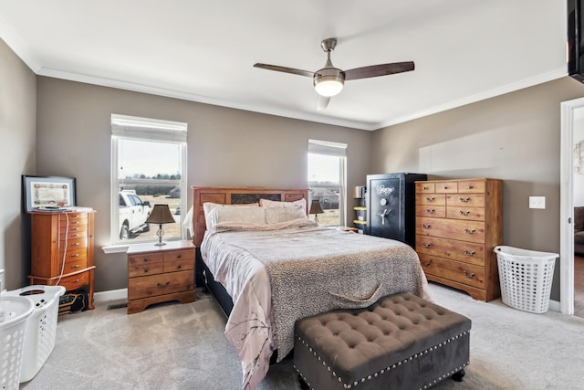 bedroom featuring ornamental molding, a ceiling fan, baseboards, and light carpet