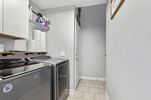 washroom with washer and dryer, light tile patterned floors, cabinet space, and baseboards