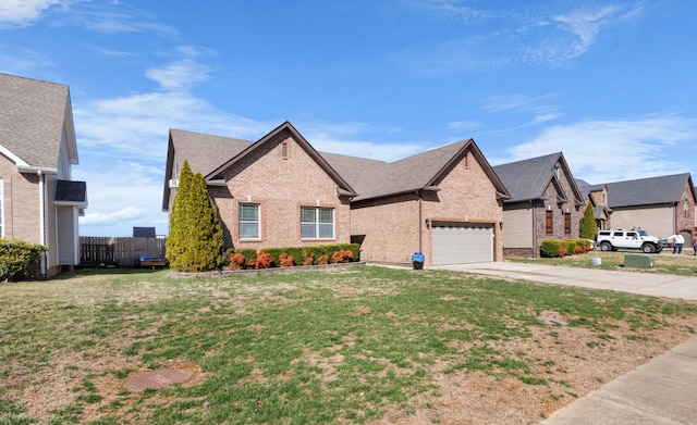 view of front of property featuring a front yard, fence, driveway, a garage, and brick siding