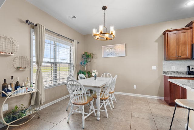 dining area with light tile patterned floors, visible vents, an inviting chandelier, and baseboards