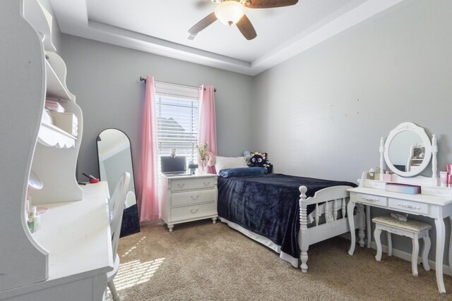 bedroom featuring light carpet, a raised ceiling, and ceiling fan