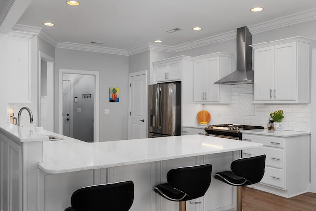 kitchen with a kitchen breakfast bar, wall chimney exhaust hood, a sink, and stainless steel fridge with ice dispenser