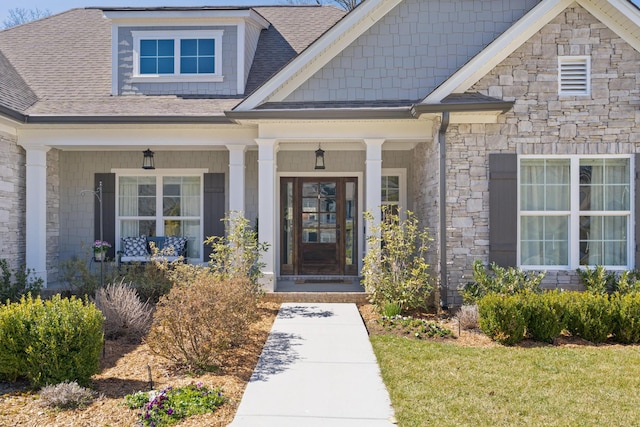 property entrance featuring stone siding and a shingled roof