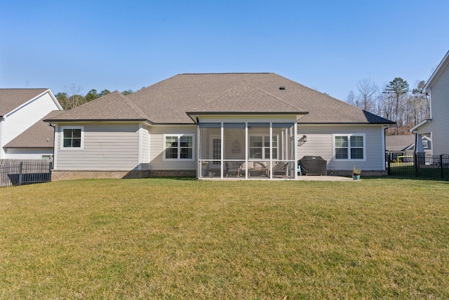 back of house featuring a sunroom, roof with shingles, fence, and a yard