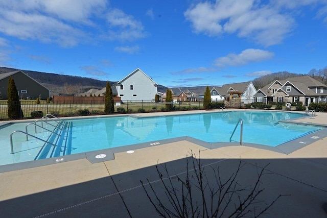 community pool with a residential view and fence