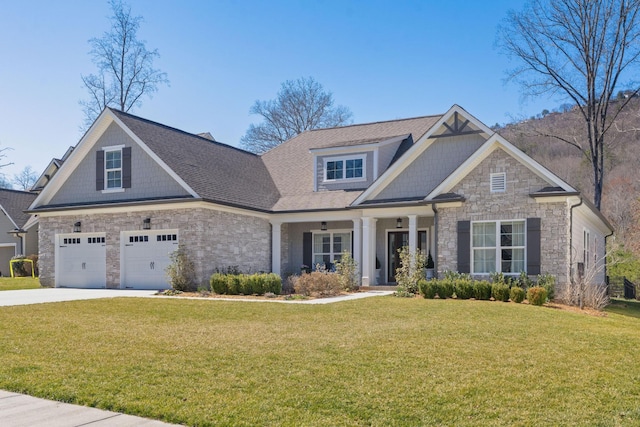 craftsman-style home featuring a garage, stone siding, driveway, roof with shingles, and a front lawn