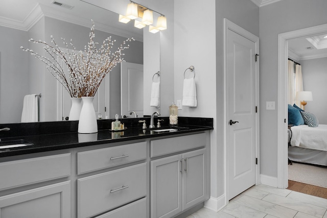 ensuite bathroom featuring ornamental molding, visible vents, a sink, and ensuite bath