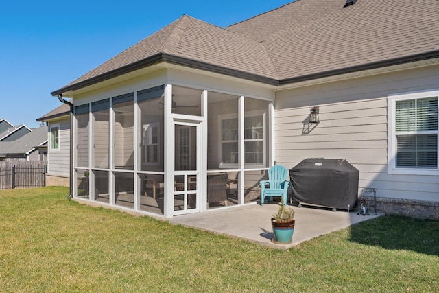 exterior space featuring a shingled roof, fence, a sunroom, a yard, and a patio area