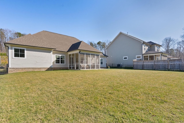 back of house with a lawn, fence, and a sunroom