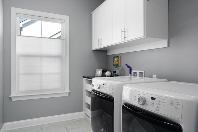 laundry room with cabinet space, baseboards, and washer and clothes dryer