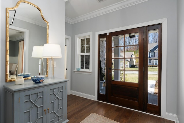 foyer with ornamental molding, dark wood-style flooring, visible vents, and baseboards