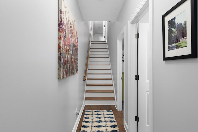 corridor with stairway, baseboards, and wood finished floors