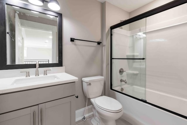 bathroom with combined bath / shower with glass door, vanity, and toilet