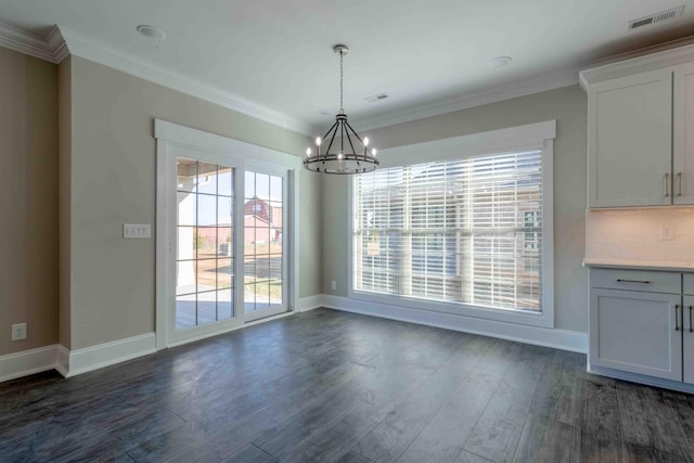 unfurnished dining area with dark wood-style floors, visible vents, crown molding, and a notable chandelier