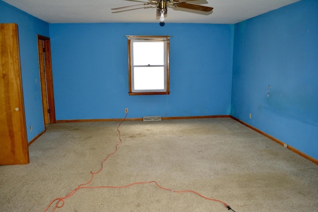 unfurnished room with baseboards, carpet, visible vents, and a ceiling fan