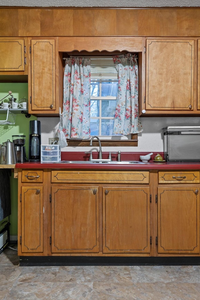 kitchen featuring brown cabinetry and a sink