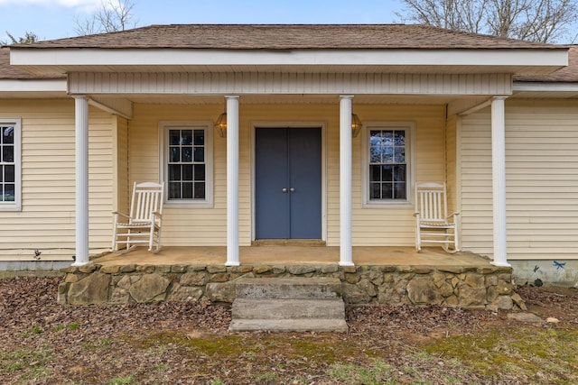 property entrance with a porch and roof with shingles