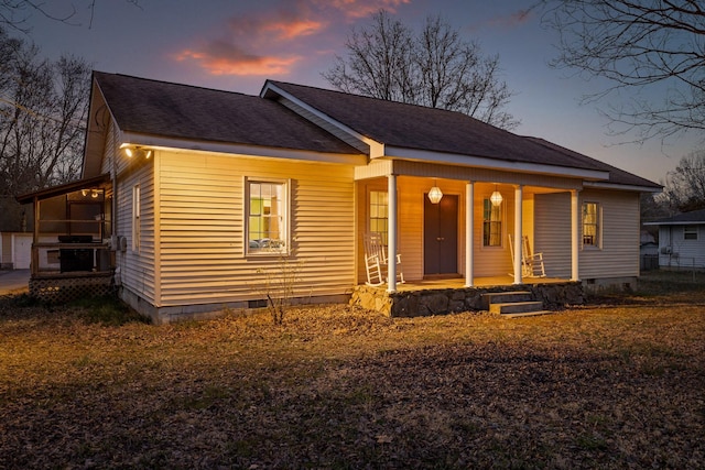 view of front of house with roof with shingles, a porch, and crawl space