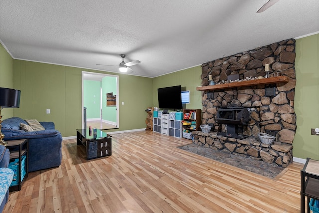 living room featuring baseboards, ceiling fan, ornamental molding, wood finished floors, and a textured ceiling