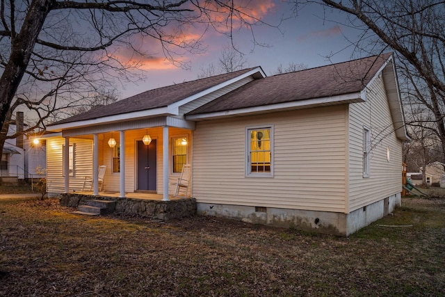 view of front facade featuring a porch, crawl space, and a shingled roof