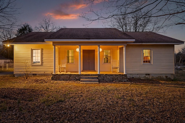 bungalow with roof with shingles, a porch, and crawl space