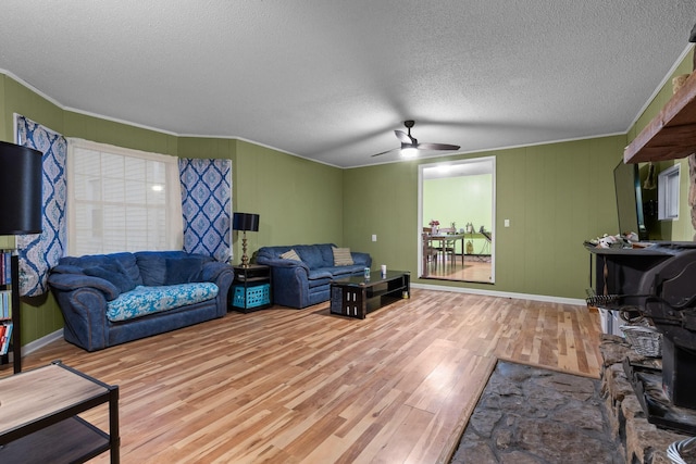 living room with ornamental molding, a ceiling fan, a textured ceiling, and wood finished floors