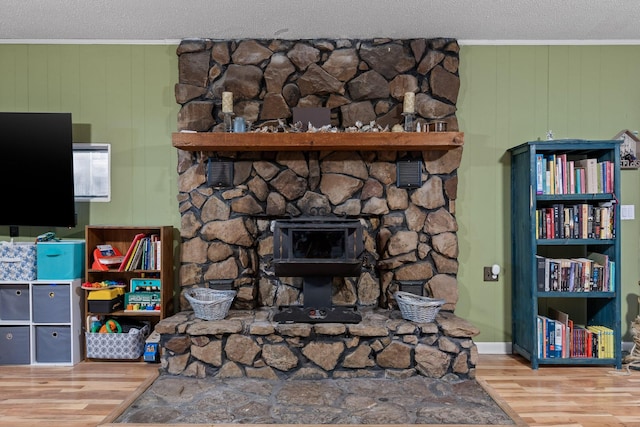 details featuring a fireplace, crown molding, a textured ceiling, and wood finished floors