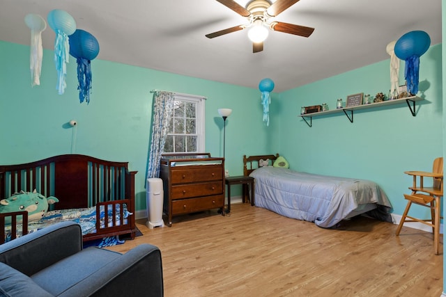 bedroom with baseboards, a ceiling fan, and wood finished floors