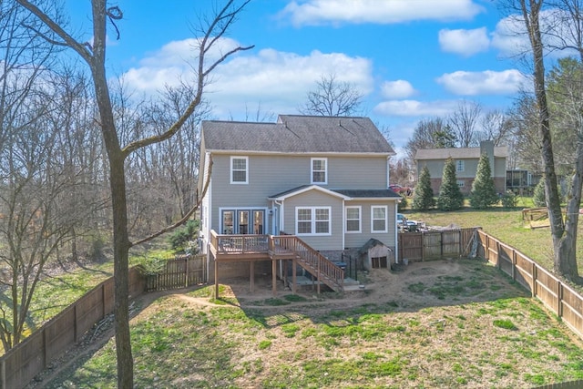 rear view of property featuring a yard, a deck, stairway, and a fenced backyard