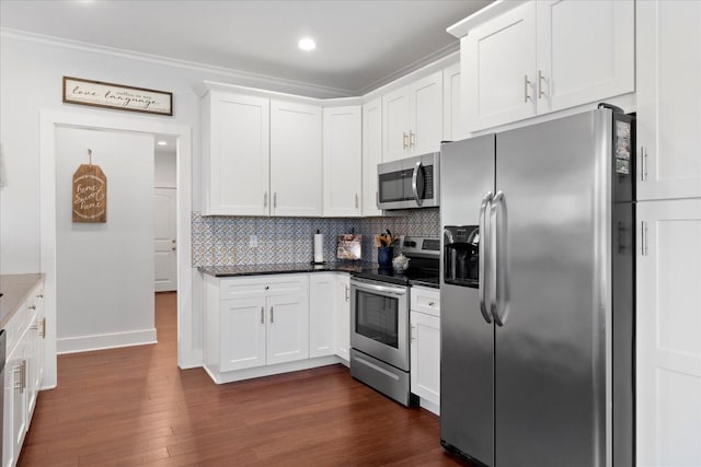 kitchen featuring baseboards, dark wood finished floors, stainless steel appliances, white cabinetry, and backsplash