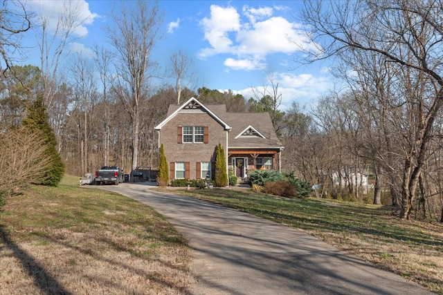 view of front of property with aphalt driveway and a front yard