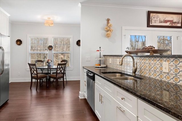 kitchen with tasteful backsplash, ornamental molding, stainless steel appliances, and a sink